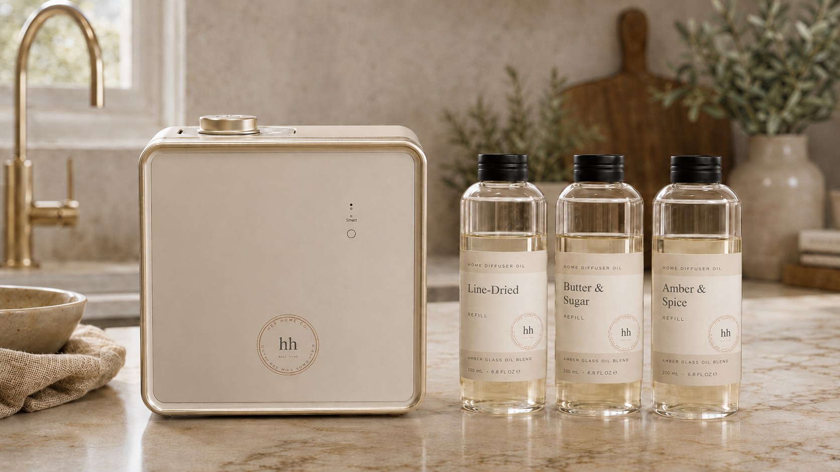 Her Home Co. — smart home diffuser with Line-Dried, Butter & Sugar, and Amber & Spice refill oils on a marble counter
